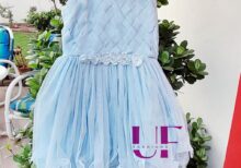 sky colored baby frock hanged on a tree